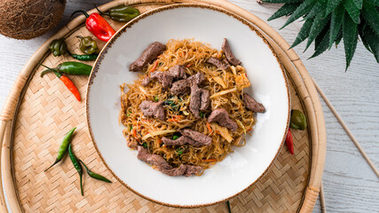 Dinner glass noodles with beef, carrots, onions, sweet peppers and green peas.