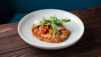 Wall Mural - Fried breaded chicken fillet with stewed vegetables, parmesan cheese and arugula.