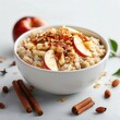 © Nat - Warm oatmeal with cinnamon and apple slices on solid white background, single object
