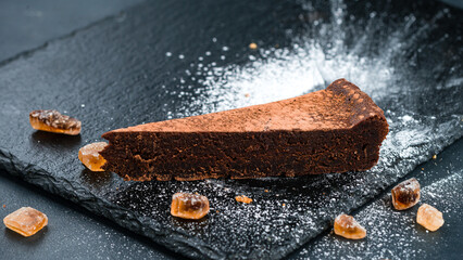 Poster - Piece of chocolate cheesecake with sweets and powdered sugar.