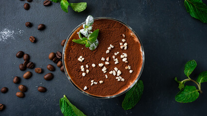 Wall Mural - Fresh dessert tiramisu in a bowl with nuts and mint.