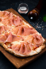 Canvas Print - Fresh Italian pizza with ham, cheese and tomato sauce on a wooden board.