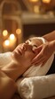 © liliyabatyrova - A woman lies comfortably on her back at a spa, receiving a soothing facial massage. The warm, dim lighting creates a peaceful atmosphere, enhancing her relaxation