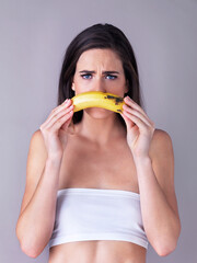 Wall Mural - Banana, mustache and portrait of woman in studio for comic, sad emotion and frown on white background. Dermatology, spa and face of person with fruit for natural skincare, wellness and organic beauty