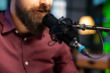 Wall Mural - Close up shot of ASMR artist using quality mic in studio to do anti stress video, whispering tingling sounds. Man using professional microphone to get sleep inducing high quality audio for meditation