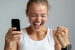 © Konstiantyn Zapylaie - Excited Woman Celebrating Success with Smartphone in Hand, Embracing Victory and Joy