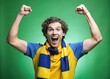 © Man888 - Thrilled young male fan enthusiastically cheers on his beloved soccer team, beaming with joy, wearing a simple tee and vibrant yellow-blue scarf, isolated on green.
