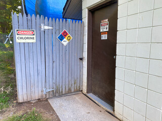 A fence with a chlorine warning sign, suggesting a hazardous area