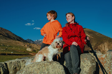 Wall Mural - Mother and son with shih tzu dog portrait in the mountains