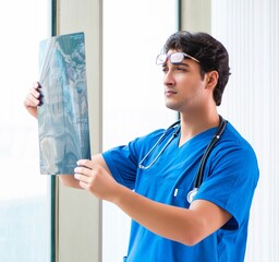 Wall Mural - Young handsome doctor working in the hospital