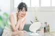© buritora - 自宅でスキンケアする笑顔のアジア人女性