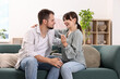 © New Africa - Happy young couple with pregnancy test on sofa at home