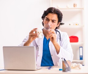 Wall Mural - Young male doctor with human's skull