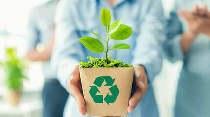 A person holds a small plant in a recyclable pot, symbolizing environmental sustainability and commitment to green practices.