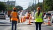 © NATTAWUT - Workers in reflective vests directing traffic around a construction zone
