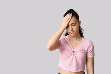 Canvas Print - Beautiful young woman suffering from headache on white background