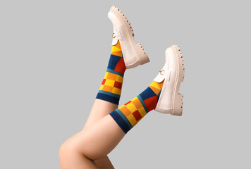 Legs of young woman in socks and shoes on white background