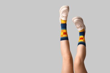 Wall Mural - Legs of young woman in socks and shoes on white background