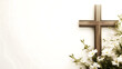 © Caelestiss - Composition with a Christian wooden cross and flowers against muted white background with copy space for text. Funeral template