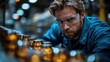 © Tomass - Male quality control inspector examining products on a factory production line wearing protective eyewear.