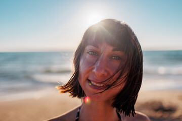 Wall Mural - Summer mood. portrait of a beautiful brunette on the beach.