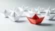© Stocks Buddy - A group of white paper boats with one red boat leading showing strong leadership, colorful paper crafts, teamwork and guidance