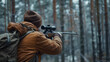 © Mahemud - Hunter during hunting in a forest, holding a rifle and aiming at a deer.