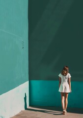 Wall Mural - Woman in White Dress Walking Away from a Green Wall