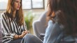 © chutikan - A female psychologist and a patient sit on a sofa. Talk and listen closely to the thoughts of patients who come to consult during psychotherapy at the hospital.