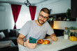 © Dusan - Young caucasian man eating croissant for breakfast