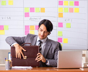 Wall Mural - Young handsome employee working in the office