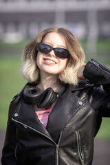 Portrait of a young beautiful girl in dark clothes in an urban environment.