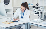 Fototapeta Zwierzęta - Microscope, scientist and writing notes for medical research in laboratory with biology or pharmaceutical results. Female person, technology and analysis for pathology, science and vaccine innovation