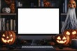© Tapanut - Spooky Halloween-themed office desk with a computer monitor surrounded by carved pumpkins and eerie decorations at night.