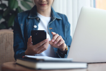 Poster - Young asian business woman using mobile phone, working on laptop computer at coffee shop. Female freelancer online working, using smartphone surfing the internet, remote work, e-learning