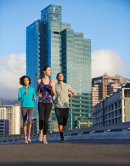 Wall Mural - Fitness, people and running with street in city for workout, training or outdoor exercise together. Young, group or runners in warm up for run, cardio or practice on street in health and wellness