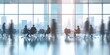 © kwanchaift - Blurred figures of businesspeople in a sleek office meeting room, with minimalist decor and a panoramic city view through large windows