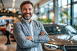 © Kowit - A man in a suit is posing in front of a car in a showroom
