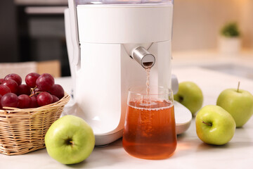 Poster - Modern juicer, fresh fruits and glass on white marble table in kitchen, closeup