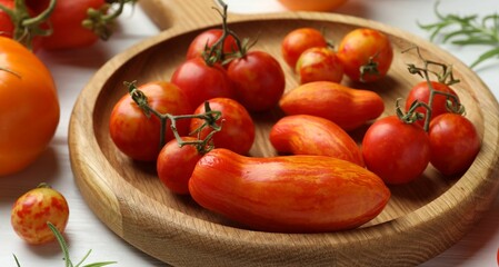 Wall Mural - Different ripe tomatoes on white wooden table, closeup