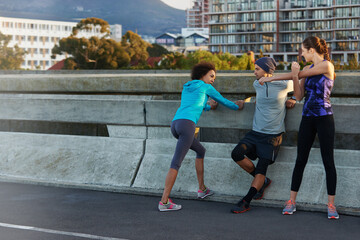 Canvas Print - Fitness, people and stretching with road in city for workout, training or outdoor exercise together. Young, group or runners in warm up for run, cardio or practice on street in health and wellness