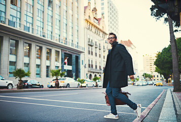 Poster - Fashion, commute and man in city, stylish clothes and pedestrian in street, startup owner and urban town. Person, glasses and guy in road, walking and New York with portrait, buildings and travel