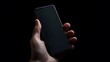 © Loki Studio - Hand holding a smartphone with a dark screen against a black background