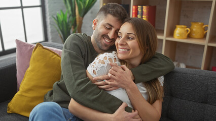 Affectionate couple embracing with love indoors, showcasing a cozy home atmosphere with a man and woman sharing a tender moment on a couch.