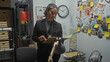 © Krakenimages.com - A focused hispanic woman detective analyzes evidence in a cluttered police department office.