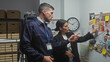 © Krakenimages.com - Man and woman officers in a police department examining evidence board with photos and notes.