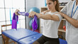 © Krakenimages.com - A woman performs resistance band exercises with the assistance of a male physiotherapist in a rehabilitation clinic