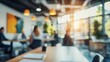 © Athena - A blurred interior shot of a modern workspace with people engaged in discussions and soft lighting creating a warm atmosphere.