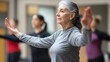 © Athena - A senior woman engages in a mindful movement class, showcasing focus and tranquility in a diverse group setting.