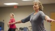 © Athena - A senior woman practices balance exercises in a fitness class, showcasing health and wellness in a supportive environment.